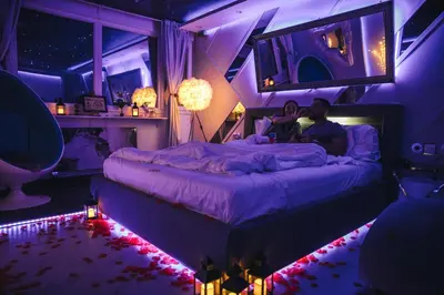 a group of people sitting on a bed in a room with purple lighting at Aurora Lux Spa Smart apartments in Belgrade