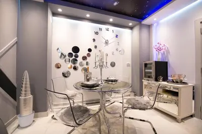a dining room with a table and a clock on the wall at Aurora Lux Spa Smart apartments in Belgrade