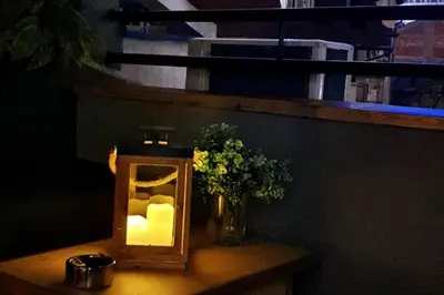 a light on a table with a vase of flowers at CHILLA MILLA in Sajmište