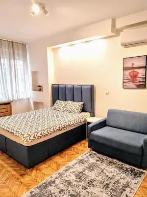 a bedroom with a bed and a couch at Belgrade apartment Bulevar in Belgrade