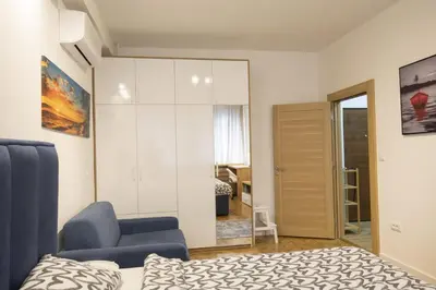 a bedroom with a bed and a chair and a closet at Belgrade apartment Bulevar in Belgrade