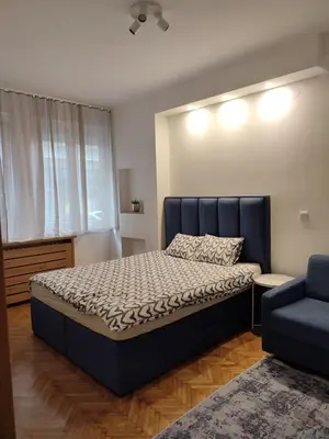 a bedroom with a large bed and a blue couch at Belgrade apartment Bulevar in Belgrade