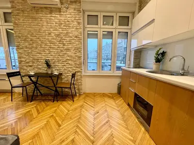 a kitchen with a sink and a table with chairs at The Bohemian Residence in Belgrade