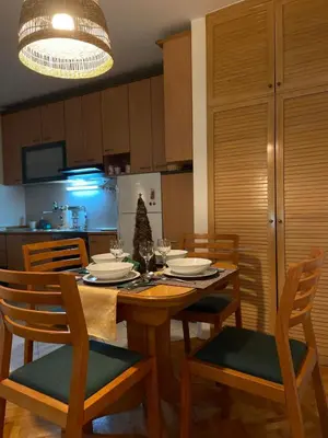 a dining room with a table and chairs and a kitchen at Bella apartment in Belgrade
