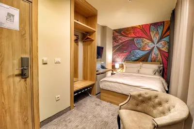 a bedroom with a bed and a chair in a room at Hotel Skadarlija NB in Belgrade