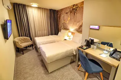 a hotel room with two beds and a desk at Hotel Skadarlija NB in Belgrade