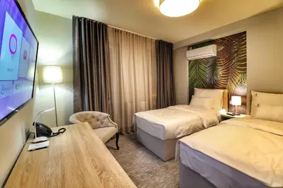 a hotel room with two beds and a flat screen tv at Hotel Skadarlija NB in Belgrade