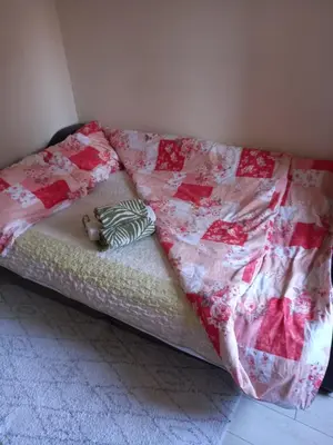 a bed with a quilt and a pillow on it at Sofia Apartment in Surčin