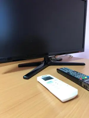 a computer monitor and a remote control on a desk at Sofia Apartment in Surčin