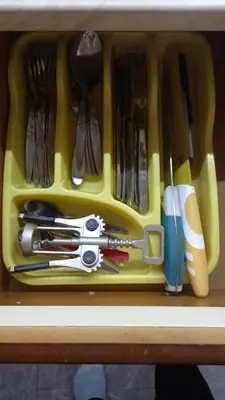 a yellow container filled with utensils in a drawer at Sofia Apartment in Surčin