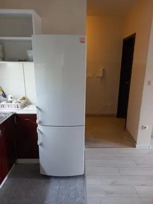 a white refrigerator in a kitchen with a hallway at Sofia Apartment 2 in Surčin