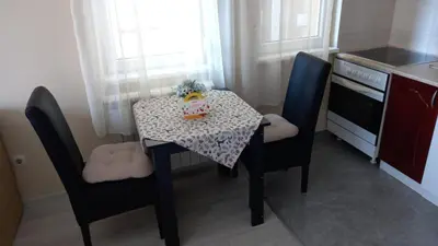 a small kitchen with a table and chairs with a cake on it at Sofia Apartment 2 in Surčin