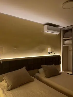 a bedroom with two beds and a light on the wall at Belgrade Pearl with free parking in Belgrade