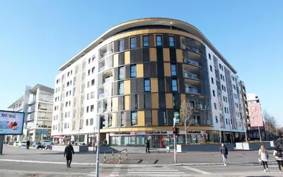 a building on a city street with people walking around it at Apartment SUN CITY 2 in Belgrade