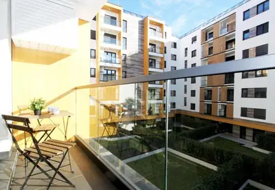 a balcony with a table and chairs on a building at Apartment SUN CITY 2 in Belgrade