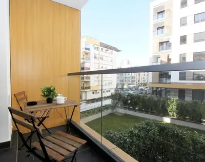 a balcony with a table and chairs and a window at Apartment SUN CITY 1 in Belgrade