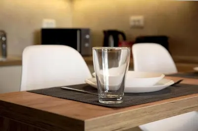 a glass of water sitting on a wooden table at Apartment SUN CITY 1 in Belgrade