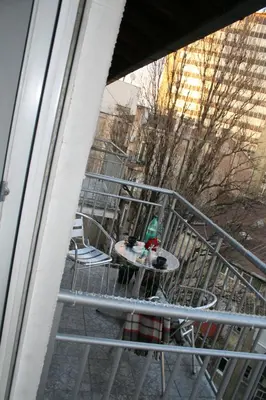 a balcony with a table and chairs on a railing at Savinac apartman u srcu Beograda, Trg Slavija in Belgrade