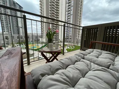 a balcony with a couch and a table with flowers at Arcadia 22 Belgrade Waterfront in Belgrade