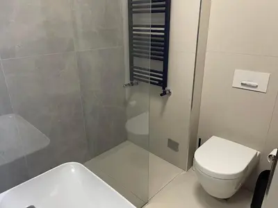 a bathroom with a shower and a toilet and a sink at Downtown in Belgrade