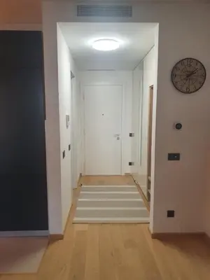 a hallway with white walls and a clock on the wall at Downtown in Belgrade