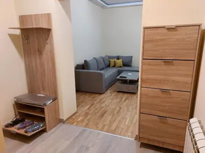 a living room with a blue couch in a room at Jež in Belgrade