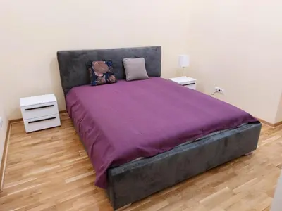 a bedroom with a large bed with a purple blanket at Jež in Belgrade