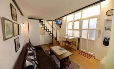 a living room with a couch and a table and a window at Central Ant Apartment in Belgrade