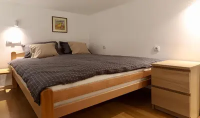 a bed with a wooden frame and a night stand at Central Ant Apartment in Belgrade