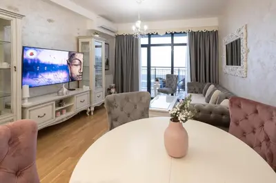 a living room with a white table and a tv at Beograd na vodi - BW ViSTA LUXURY in Belgrade