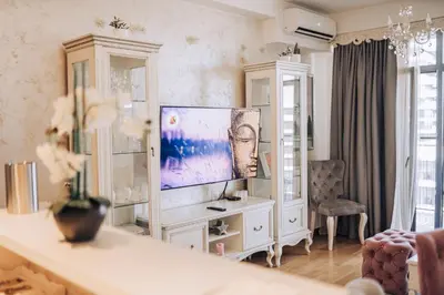 a living room with a television on a white cabinet at Beograd na vodi - BW ViSTA LUXURY in Belgrade