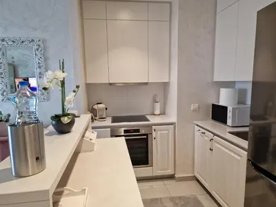 a kitchen with white cabinets and a counter top at Beograd na vodi - BW ViSTA LUXURY in Belgrade