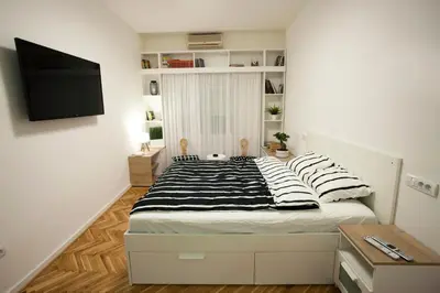 a bedroom with a bed with black and white pillows at Studio 10 in Belgrade