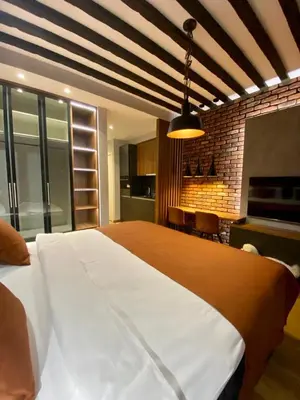 a bedroom with a large bed and a brick wall at BW Sky View, 23rd Floor, Belgrade Waterfront in Belgrade
