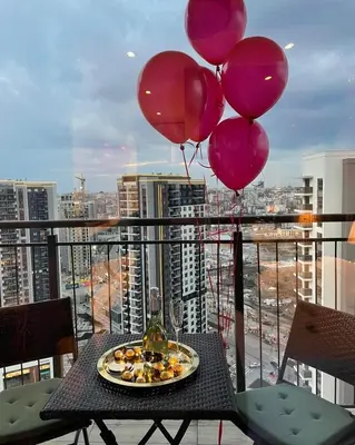 a table with balloons and a plate of food on a balcony at BW Sky View, 23rd Floor, Belgrade Waterfront in Belgrade