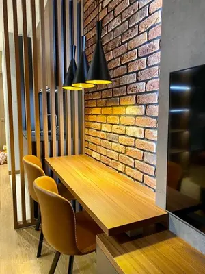 a dining room table with chairs and a brick wall at BW Sky View, 23rd Floor, Belgrade Waterfront in Belgrade