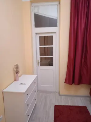 a room with a white door and a dresser and a window at Bajloni lux in Belgrade