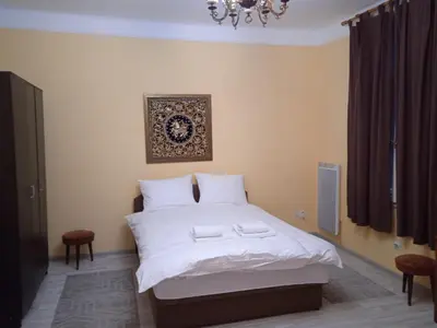 a bedroom with a white bed with a picture on the wall at Bajloni lux in Belgrade
