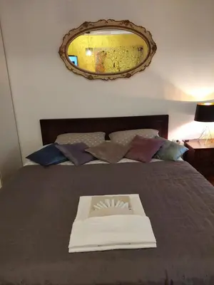 a book sitting on top of a bed with a mirror at Room 23 in Belgrade