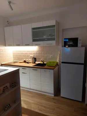 a kitchen with white cabinets and a white refrigerator at Room 23 in Belgrade