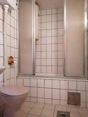 a white tiled bathroom with a toilet and a shower at Central location for you in Belgrade