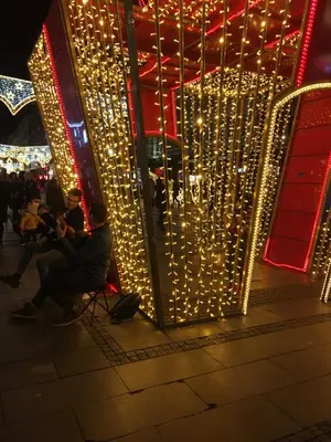 a group of people sitting in front of a building with lights at Central location for you in Belgrade