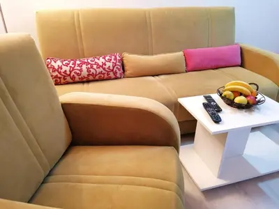 a couch with a bowl of fruit on a table at Central location for you in Belgrade