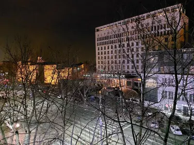 a tall building at night with snow on the ground at Boulevards apartment in Belgrade