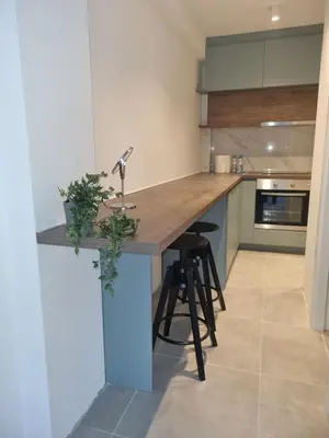 a kitchen with a wooden counter with stools at Parliament View Apartments in Belgrade