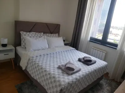 a bedroom with a bed with towels on it at B-G Waterfront Apartment in Belgrade