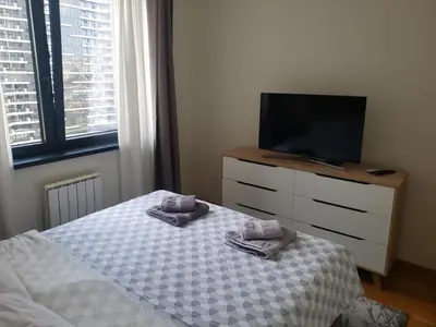 a bedroom with a bed and a tv on a dresser at B-G Waterfront Apartment in Belgrade