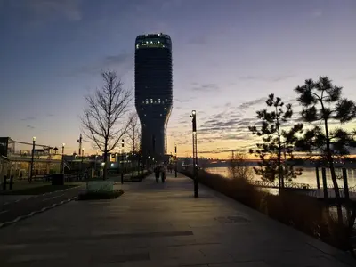 a tall building with lights on it next to a river at B-G Waterfront Apartment in Belgrade