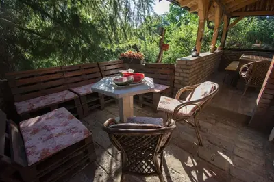a patio with a table and chairs and a bench at Happy house in Velika Remeta