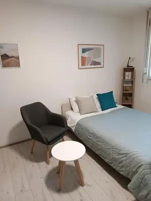 a bedroom with two beds and a chair and a table at Sleep&Go in Belgrade